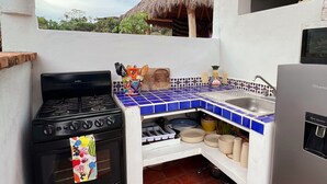 A compact kitchen with a gas stove, a sink, and a refrigerator. - Complimentary 1 hr Massage in our Traditional Open-Air Palapa w/ Private Pool (Sayulita)