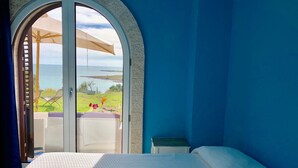 A bedroom with a large arched window overlooking a grassy area and a body of water. - CAMELIA by KlabHouse-2BR w/AC&Terrace-walk2beach (Sciacca)