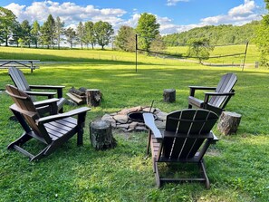 Area verde con Adirondack e un braciere.