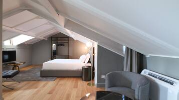 Un dormitorio moderno con cama, mesita de noche, lámpara y televisor.