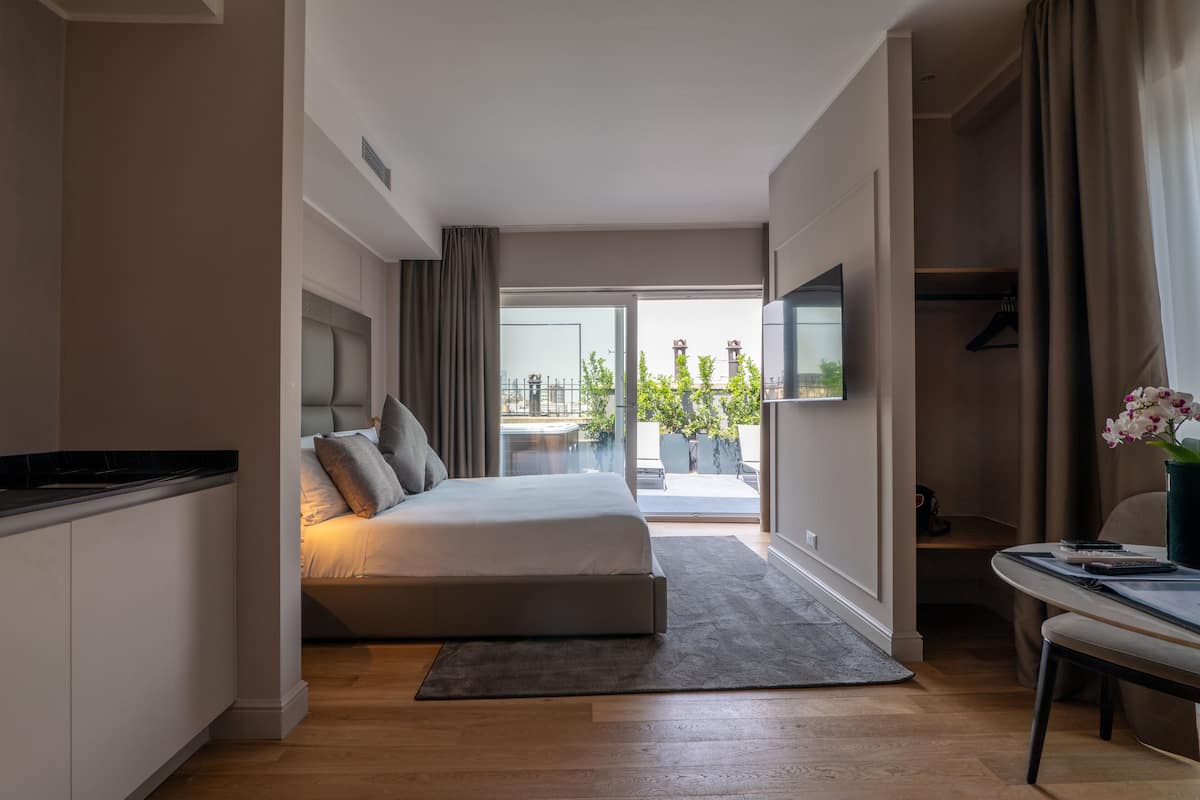 Habitació d'hotel moderna amb llit, escriptori i vista a l'exterior.