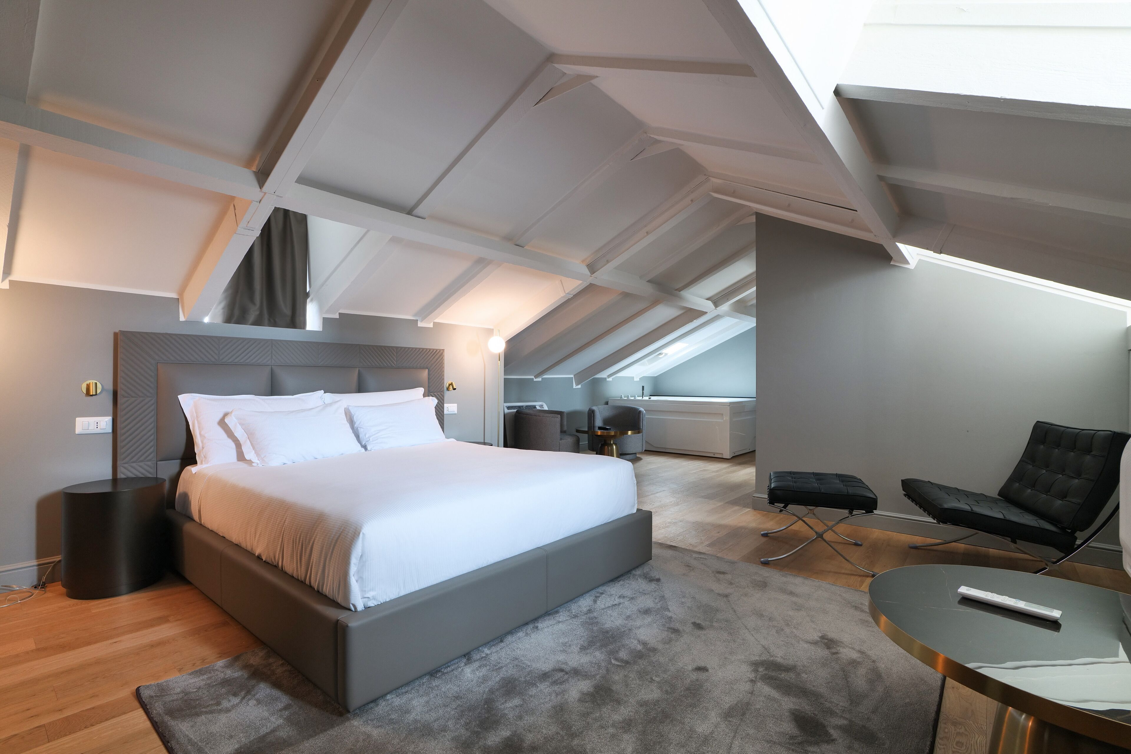 Ein modernes Schlafzimmer mit einem großen Bett, einem Schreibtisch und einem Sessel.