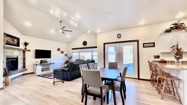 A spacious living area with a fireplace, a dining table with chairs, a sofa, and a kitchen area with a countertop and chairs. - New home, close to skiing, hunting, rodeos, hiking. Fenced yard, pet friendly. (Darby)