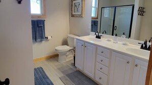 A modern bathroom with a white vanity, double sink, and a large mirror. - New cabin- access to horse trails, Pilot Mtn & Hanging Rock St. Pks (Pinnacle)