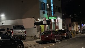 A hotel with a neon sign, parked cars, and a no parking sign. - Hotel Bandeirantes (Sao Joao da Boa Vista)