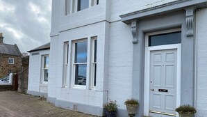 A white building with a white door marked "13 ABC" and a window with a sign "MELBOURNE ROYAL". - Stunning location - beachfront ground floor flat with private parking. Fab views (North Berwick)