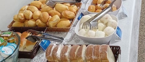 Una mesa de buffet con diversos alimentos y utensilios para servir.