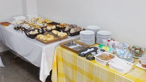 A buffet table with various food items and serving utensils. - Days inn by Wyndham Uberlândia (Uberlandia)