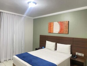 A hotel room with a bed, a nightstand, a phone, and a wall-mounted artwork. - Days inn by Wyndham Uberlândia (Uberlandia)