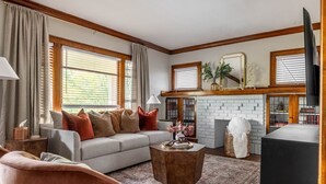A living room with a grey sofa, wooden coffee table, and a fireplace. - Stunning 3BR - Near Cleveland Clinic Main Campus (Cleveland Heights)