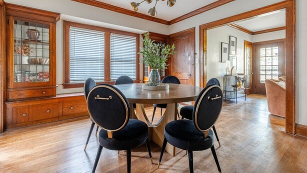 A dining room with a round table, four chairs, a chandelier, wooden cabinets, and a potted plant. - Stunning 3BR - Near Cleveland Clinic Main Campus (Cleveland Heights)