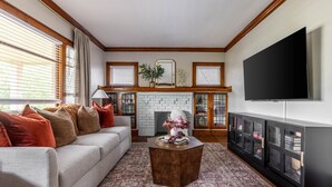 A living room with a sofa, coffee table, fireplace, and a TV. - Stunning 3BR - Near Cleveland Clinic Main Campus (Cleveland Heights)