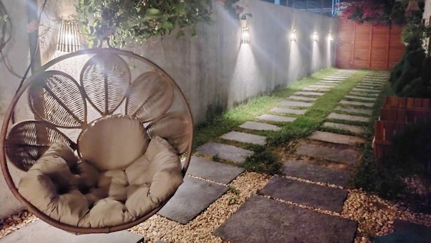 A garden pathway with a hanging chair and wall-mounted lights. - Casa Refúgio das Águias na Praia do Preá (Cruz)