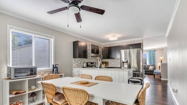 A modern kitchen with white cabinets, a built-in oven, and a stainless steel refrigerator. - Fun & Cozy Retreat: Nature & Games (Quinte West)