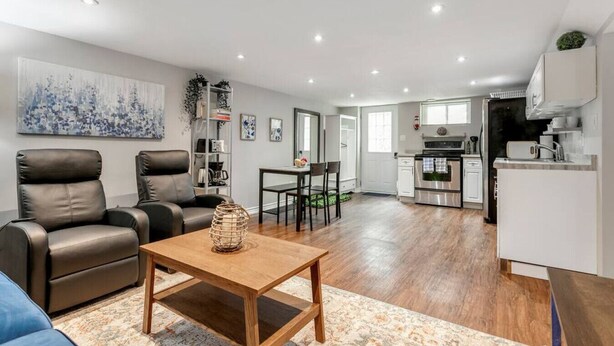 A modern living room with a sofa, a wooden coffee table, and a dining area with chairs.