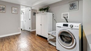 A laundry room with a washing machine, a dryer, and a cabinet.