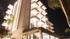A modern building with multiple balconies, a staircase, and a well-lit entrance area. - Demi Hotel (Sarandë)