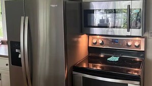 A kitchen with a stainless steel refrigerator, oven, and microwave. - Hot Tub in the Forest Cozy Home on Peaceful Lake (Mountain)