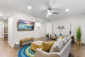 A modern living room with a sofa, a coffee table, a TV, and decorative items.