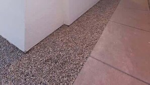 Um edifício moderno com telhado plano, um caminho estreito e luzes de corda na borda.