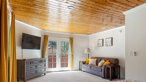 Un dormitorio con techo de madera, un aparador, un sofá y una cama.