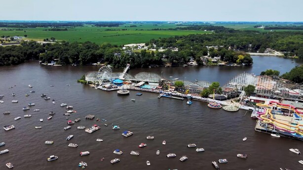 A river with numerous boats and a park with rides and a Ferris wheel. - Key Lime Resorts - Unit #1 RV Retreat Villa (Monticello)