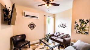 A living room with a ceiling fan, a sofa, a coffee table, and a patterned rug. - Coastal Purple: Minutes to Cedar Point & Sports Complex! Sleeps 9 (Sandusky)