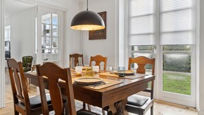 Un coin repas avec une table en bois, des chaises et une suspension.