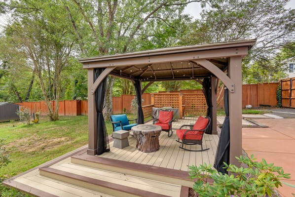 Relax in a shaded outdoor space with comfortable seating and a round table.
