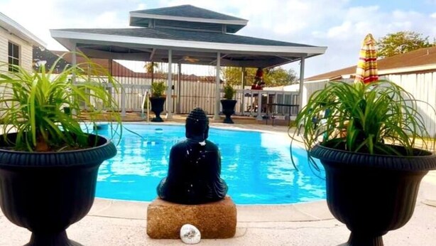 A statue of a seated figure by a pool, with two potted plants on either side. - Casa Santa Clara with Swimming Pool near Golf Country Clubs (Brownsville)