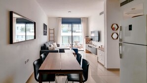 Eine moderne Küche mit Essbereich, einer Couch und einem Fernseher.