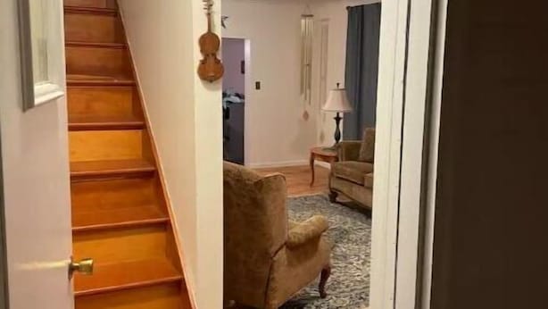 Eine Treppe führt in ein Wohnzimmer mit Sofa und Lampe.