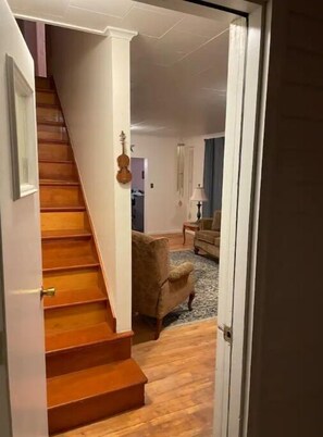 Una escalera que conduce a una sala de estar con un sofá y una lámpara.