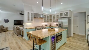 A modern kitchen with a central island, built-in cabinets, and a large refrigerator. - Luxury Lakefront Retreat w/ Deck & Patio! (Edgemont)