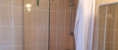 Un baño con ducha, inodoro y lavabo.