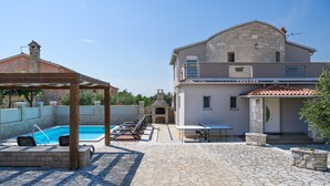 A spacious backyard with a swimming pool, outdoor seating, and a stone patio. - Lovely home in Vodnjan (Vodnjan)