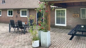 An outdoor seating area with a brick floor, a wooden pergola with climbing plants, and a sign reading "Gelok". - Lovely home in Putten with kitchen (Putten)