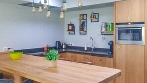 A modern kitchen with wooden cabinets, a wooden countertop, a sink, and a built-in oven. - Gorgeous home in Sint-Oedenrode (Sint-Oedenrode)