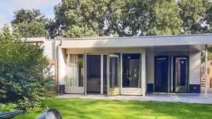 A modern house with a covered patio area, a lawn, and a garage. - Gorgeous home in Sint-Oedenrode (Sint-Oedenrode)