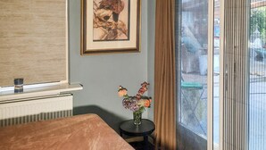 A room with a large window, a framed artwork on the wall, and a small table with a vase of flowers. - Gorgeous home in Sint-Oedenrode (Sint-Oedenrode)