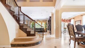 A spacious interior with a grand staircase, a dining area, and a view of the outdoors. - Vacation house with spa, pool, and water slide. (El Cajon)