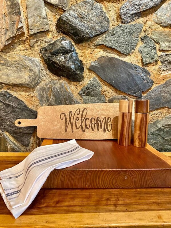 Ein hölzernes Schild mit der Aufschrift "Welcome", angebracht an einer Steinmauer.