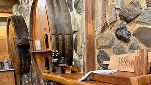 Eine rustikale Küche mit Steinwänden, Holzfässern und einem 'Welcome'-Schild.