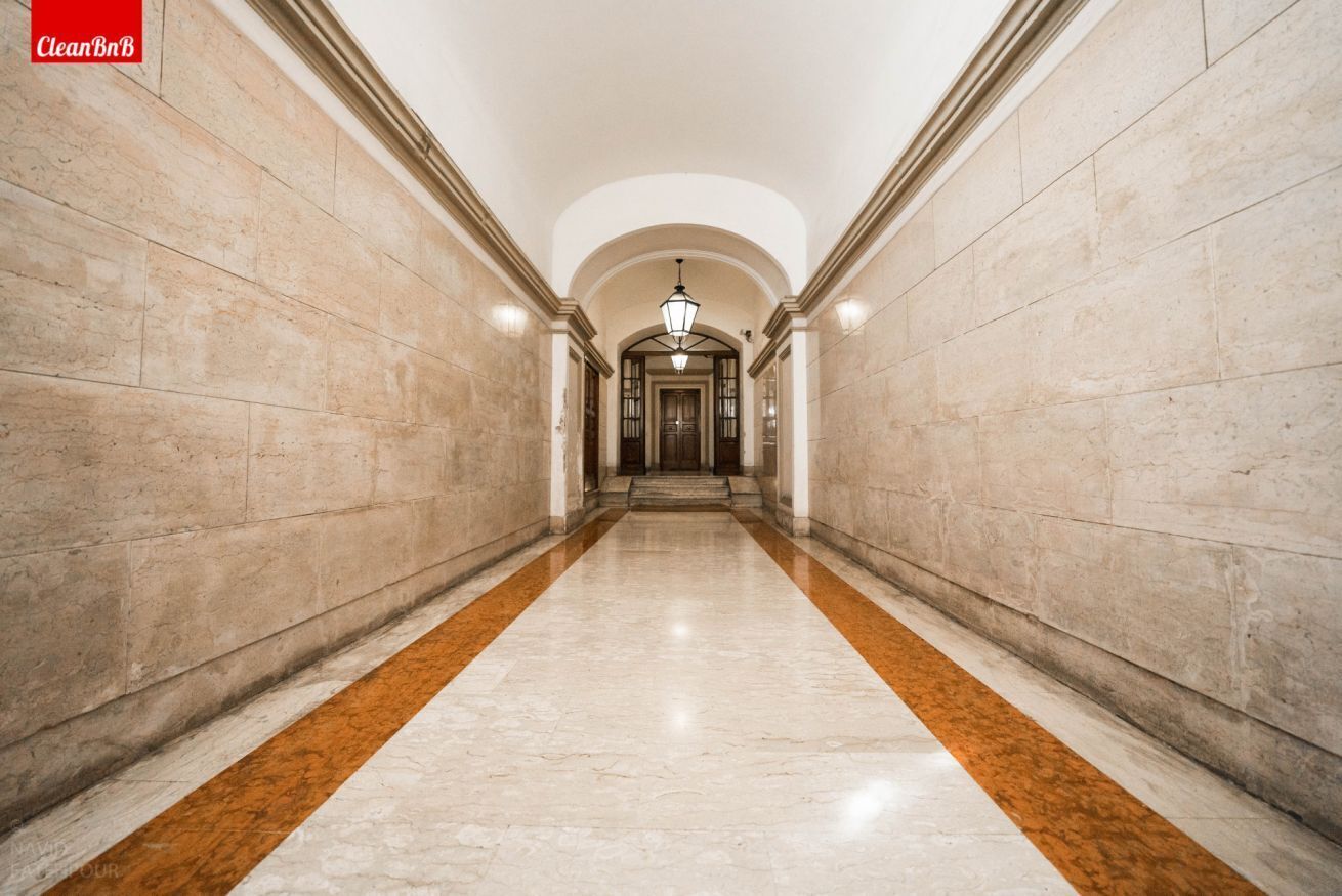 A hallway with marble walls and a central light fixture.