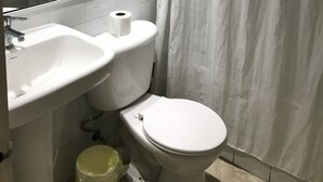 A bathroom with a white sink, toilet, and shower curtain. - Amplio y Cómodo Departamento Full Amoblado a Pasos de Chinchorro , Mall (Arica)