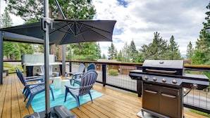 A deck with a grill, chairs, and a table under a covered area. - Steps to Beach: Family Home w/ Views in Tahoe City (Tahoe City)