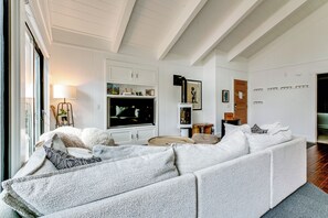 Una sala de estar moderna con un sofá modular, un televisor de pantalla plana y una chimenea.