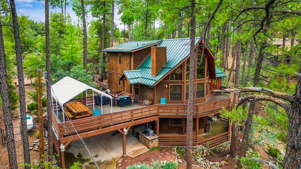 Een chalet met terras, een overdekte buiten zithoek en een stenen fundering.