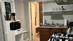 A compact kitchen with a microwave, stove, and a coffee station. - Chic Madison Parkview
 (Albany)
