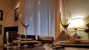 A neatly arranged dining table with two wine glasses, a glass of water, and a lamp.